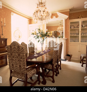 Tapisserie Chandelier de chaises rembourrées et table en acajou au townhouse salle à manger avec papier peint damassé Banque D'Images
