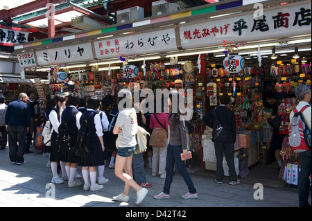 La rue commerçante Nakamise-dori près du temple Sensoji est bordée de boutiques touristiques et bondée de touristes et de clients, à Asakusa, Tokyo, Japon. Banque D'Images