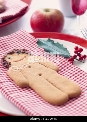 Close-up of gingerbread man avec nom de l'endroit glacé sur vichy rouge serviette de table Banque D'Images