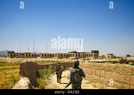 Une patrouille conjointe entre les soldats de la Force internationale d'assistance à la sécurité et des militaires de l'Armée nationale afghane revient à leur base. Banque D'Images