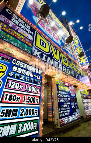 Enseignes au néon d'un adult video shop illuminent la nuit dans le quartier des divertissements d'Okachimachi, Tokyo. Banque D'Images