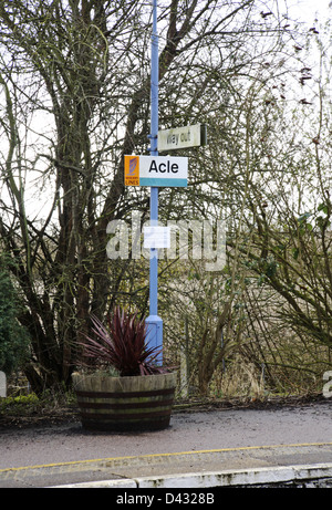 Un lampadaire avec des signes sur une plate-forme à la gare à Acle, Norfolk, Angleterre, Royaume-Uni. Banque D'Images