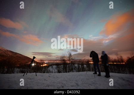 Les touristes avec trépied et appareil photo mis en place pour photographier les aurores boréales aurores boréales tourbillonnant près de Tromso, dans le nord de la norvège Banque D'Images