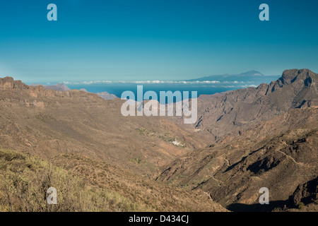 Afficher le long de la gigantesque gorge de Barranco de Tejeda, Gran Canaria, avec volcan Teide, Ténérife, visible au-dessus de 100 km Banque D'Images