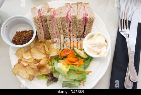 Café le déjeuner un sandwich au jambon dans du pain complet avec de la salade de chou et les chips de farine de moutarde douce Banque D'Images