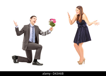 Jeune homme romantique donnant un bouquet de fleurs à une femme isolée sur fond blanc Banque D'Images