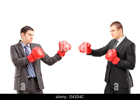 Deux jeunes hommes d'affaires avec des gants de boxe ayant un combat isolé sur fond blanc Banque D'Images