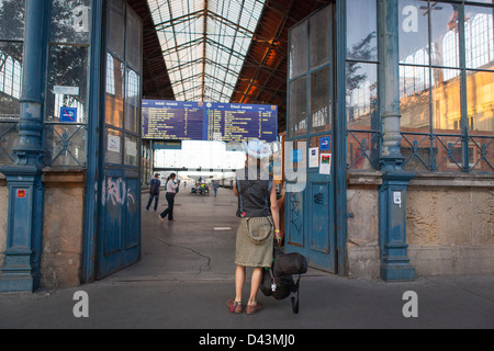 Young Pretty woman traveler avec une guitare qui composent son esprit à une gare à Budapest Banque D'Images