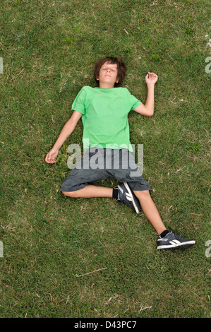 Boy Lying on Grass, Ile de Ré, Poitou-Charentes, France Banque D'Images