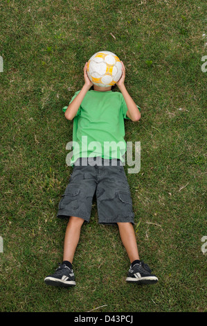 Boy Lying on Grass, Ile de Ré, Poitou-Charentes, France Banque D'Images