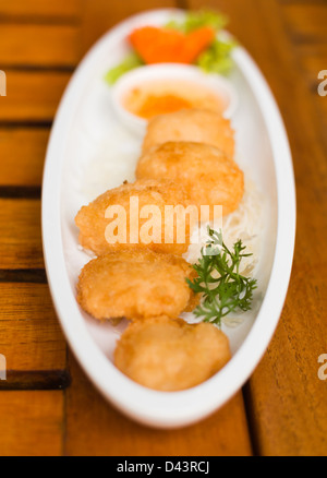 Gâteaux de crevettes poêlées sur blanc plat sur table en bois nourriture thaïe Banque D'Images