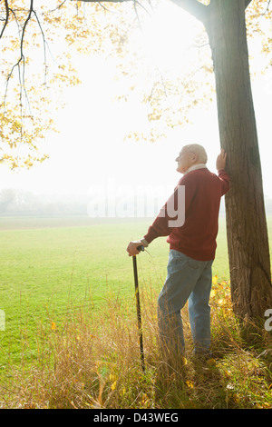 Man Standing canne par arbre, Lampertheim, Hesse, Allemagne Banque D'Images