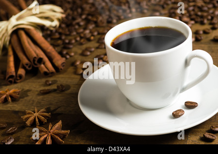 Une tasse de café avec des grains de café et des bâtons de cannelle Banque D'Images