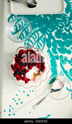 Vue de dessus de Berry en dessert bol en verre avec des cuillères sur la table avec la nappe en Studio Banque D'Images