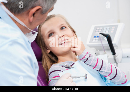 Girl montrant une dent à dentiste au cours de rendez-vous, Allemagne Banque D'Images