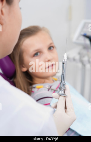 Girl aiguille tenue par un dentiste, Allemagne Banque D'Images