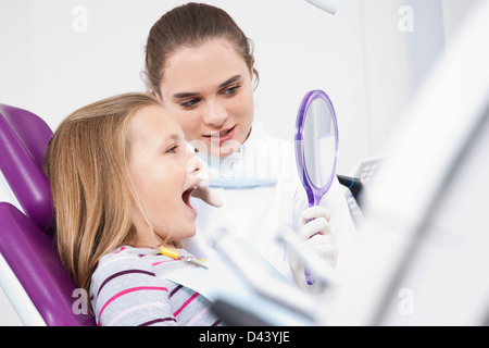 Dentiste tenant un miroir et dent lors de rendez-vous, Allemagne Banque D'Images