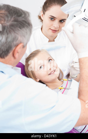 Fille avec un dentiste et hygiéniste dentaire au Bureau du dentiste, Allemagne Banque D'Images