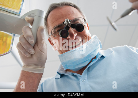 Close-up de dentiste avec loupe sur lunettes en cabinet dentaire, Allemagne Banque D'Images