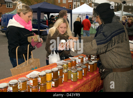 Client qui achète des bocaux de conserve à farnham Farmers' Market, Farnham, Surrey, Royaume-Uni. Banque D'Images