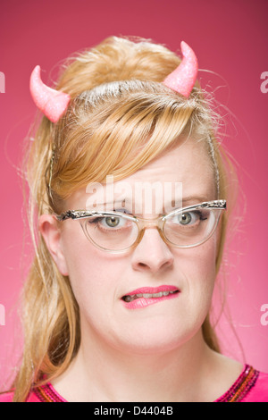 Portrait de femme portant des cornes de diable et lunettes Vintage Banque D'Images