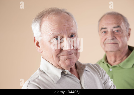 Portrait of Senior Man Looking at Camera, Studio Shot sur fond beige Banque D'Images