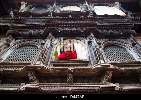 Femme à la fenêtre de son ancienne maison, Panauti village, près de Katmandou, Népal Banque D'Images