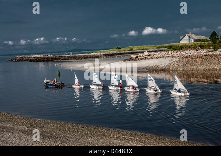 Le tout dans une ligne, une catégorie de jeunes marins sont remorqués jusqu'à la mer pour une leçon sur la voile. Banque D'Images