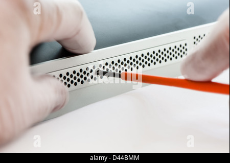 Technicien en informatique de la dépose d'un couvercle de protection pour accéder aux serveurs d'un disque dur de remplacement. Banque D'Images