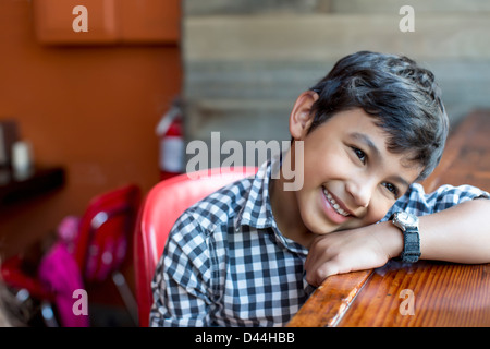 Mixed Race boy leaning on bar Banque D'Images