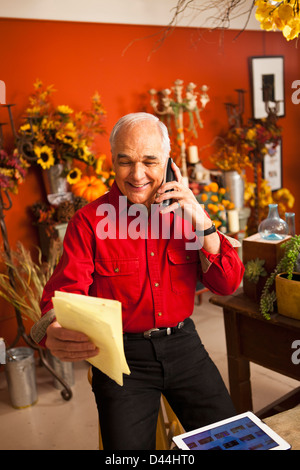 Fleuriste Caucase parlant au téléphone en boutique Banque D'Images