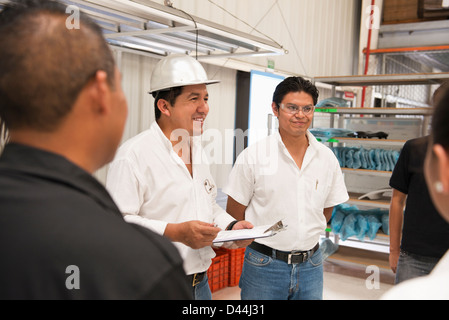 Workers talking in manufacturing plant Banque D'Images