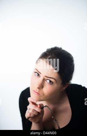 Une jeune femme, les cheveux bruns, assise seule, à la triste bas enfoncé lonely UK Banque D'Images