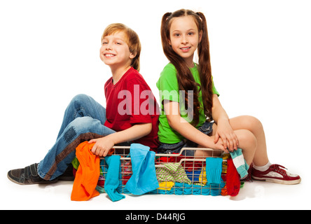 Deux enfants de huit ans dans le panier vêtements isolated on white Banque D'Images