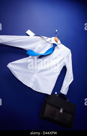 Une chemise tenue un sac accroché sur un cintre soufflant Banque D'Images