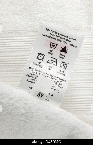 Gros plan d'une serviette de bain blanc soft touch 100  % coton égyptien avec instructions de lavage label Banque D'Images