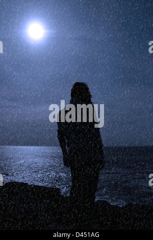 Une femme seule à bord malheureusement sur les falaises dans le comté de Clare Irlande pendant une tempête de pluie Banque D'Images