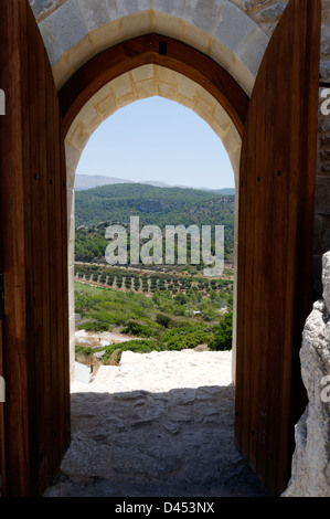 Rhodes. La Grèce. Vue sur les oliveraies à travers la porte voûtée de Kritinia Castello château sur la côte ouest de l'île de Rhodes Banque D'Images