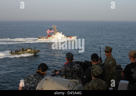 Une commande des vitesses bateau fluvial aux côtés de la U.S. Coast Guard Cutter Adak. Banque D'Images