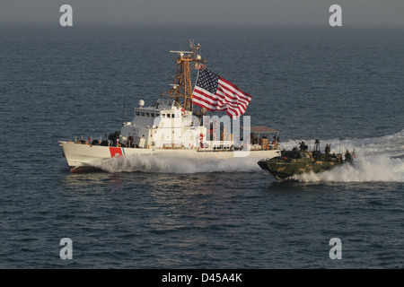 Une commande des vitesses bateau fluvial aux côtés de la U.S. Coast Guard Cutter Adak. Banque D'Images