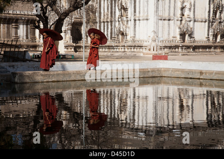 Deux moines marcher a adopté un plan d'eau au Temple Ananda Pahto, Bagan. Banque D'Images