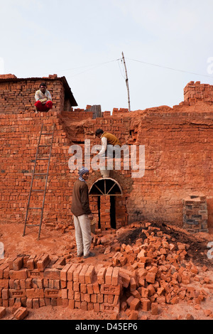 Un Punjabi traditionnel avec trois travailleurs d'une usine de production de briques retrait après le tir. Banque D'Images