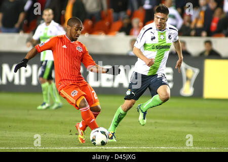 Houston, Texas, USA. 5 mars, 2013. Houston Dynamo defender Corey Ashe # 26 cherche à maintenir la possession du ballon lors de la Ligue des Champions de la CONCACAF football match quart de finale entre le Dynamo de Houston et Santos Laguna de la Liga BBVA Compass mexicain de stade à Houston, TX. Banque D'Images