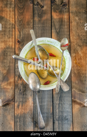 Assiette à soupe avec des piments et cinq cuillères Banque D'Images