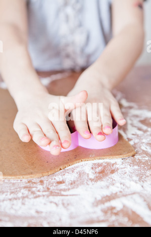 Libre des mains de jeune fille d'épice de coupe avec la pâte de biscuit en forme de coeur metal cutter Banque D'Images