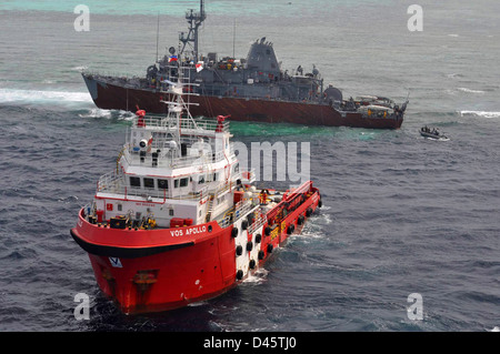 Remorqueur malaisien se prépare pour de-alimenter près de USS Guardian. Banque D'Images