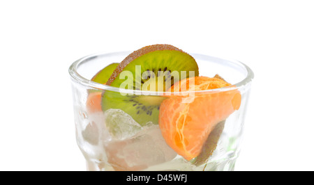 La mandarine et les tranches de kiwi dans un verre de glace pilée sur fond blanc Banque D'Images