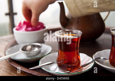 Boire thé turc traditionnel avec du thé turc tasse et plateau en cuivre, pot et manger tost avec des amis. Banque D'Images