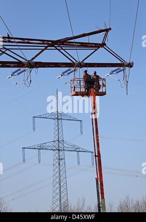 Les techniciens travaillent sur un 110 000 volts d'alimentation haute tension à proximité de pôle Espenhain, Allemagne, 5 mars 2013. Poteaux électriques exploités par le fournisseur d'énergie régional EnviaM sont transférées en raison de travaux sur la future A72. Utilise ce EnviaM comme une opportunité de remplacer les anciennes lignes électriques datant de 1963 avec un plus efficace 110-kilo volts ligne électrique qui a une durée de vie de 70 à 80 ans. Photo : Jan Woitas Banque D'Images