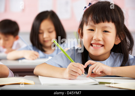 Groupe d'étudiants travaillant à un bureau en classe de l'école chinoise Banque D'Images